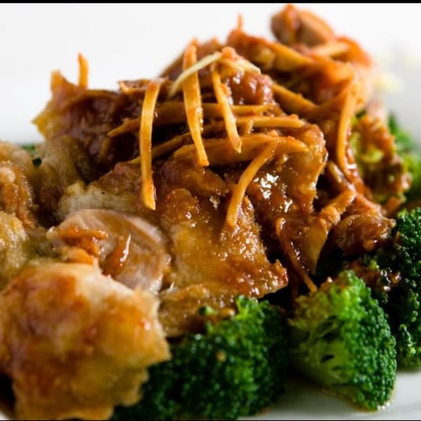 Thai Corner Food Express's chicken with broccoli and a savory brown sauce, garnished with shredded ginger.